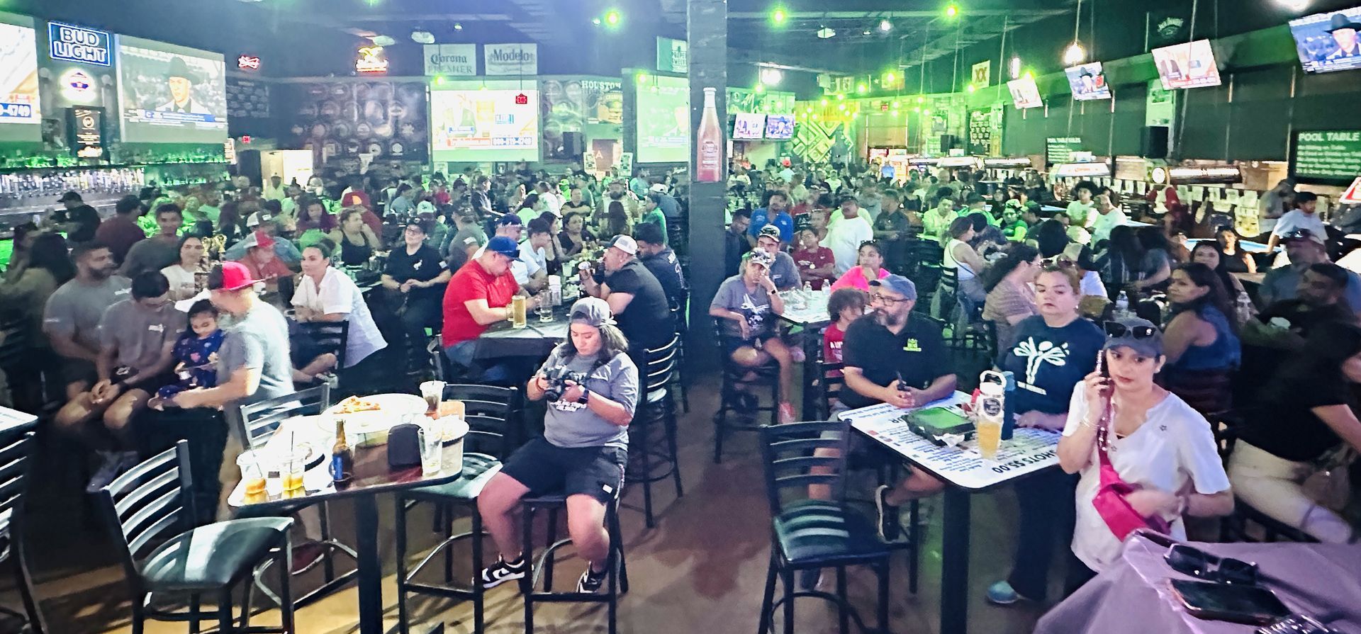 A large group of people are sitting at tables in a restaurant.