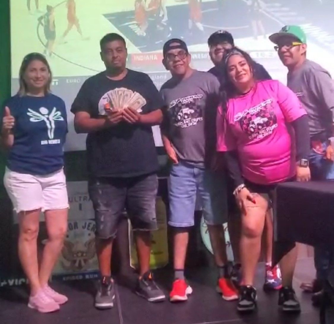 A group of people are posing for a picture and one woman is wearing a blue shirt