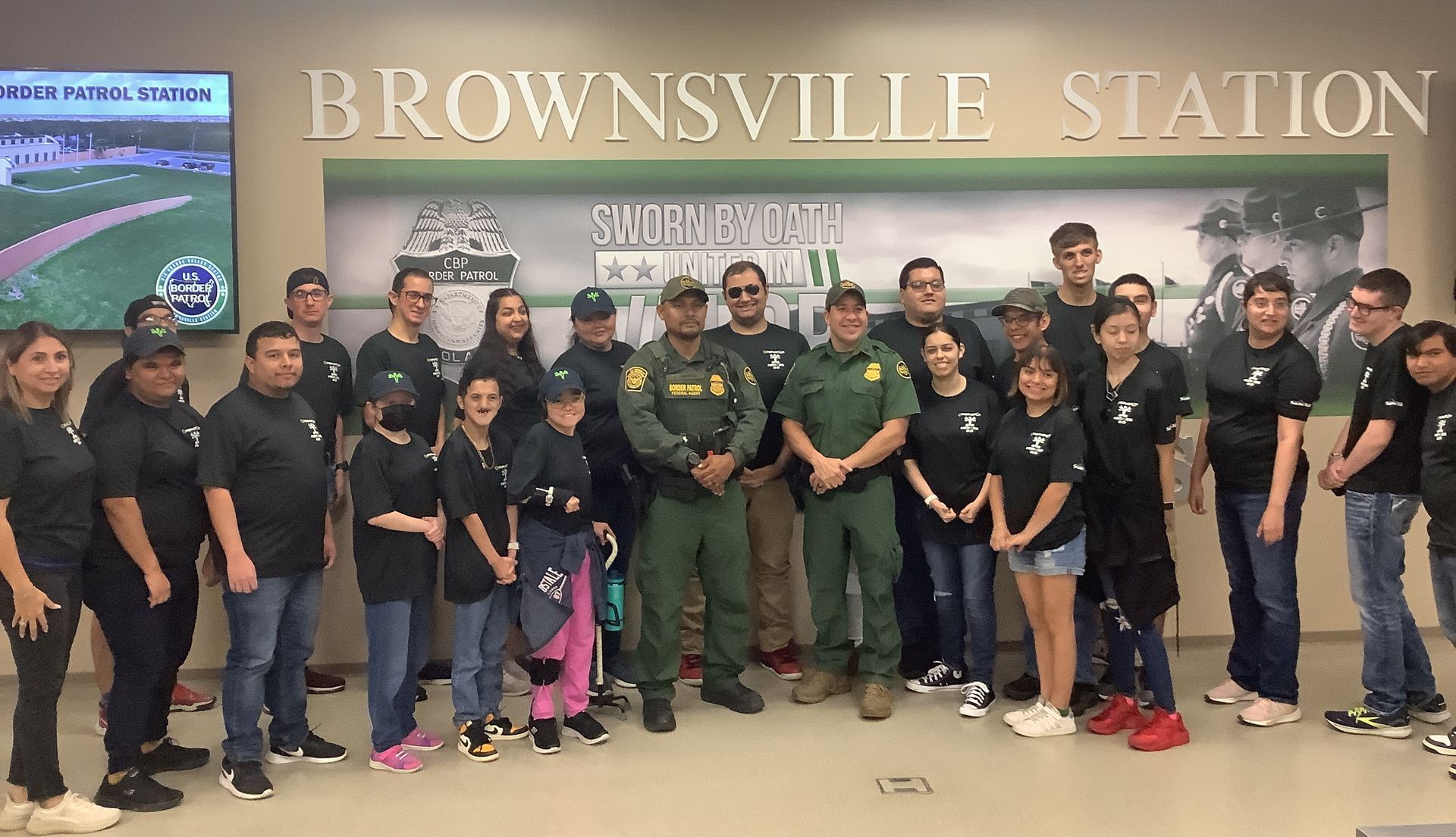 A group of people standing in front of a sign that says brownsville station.