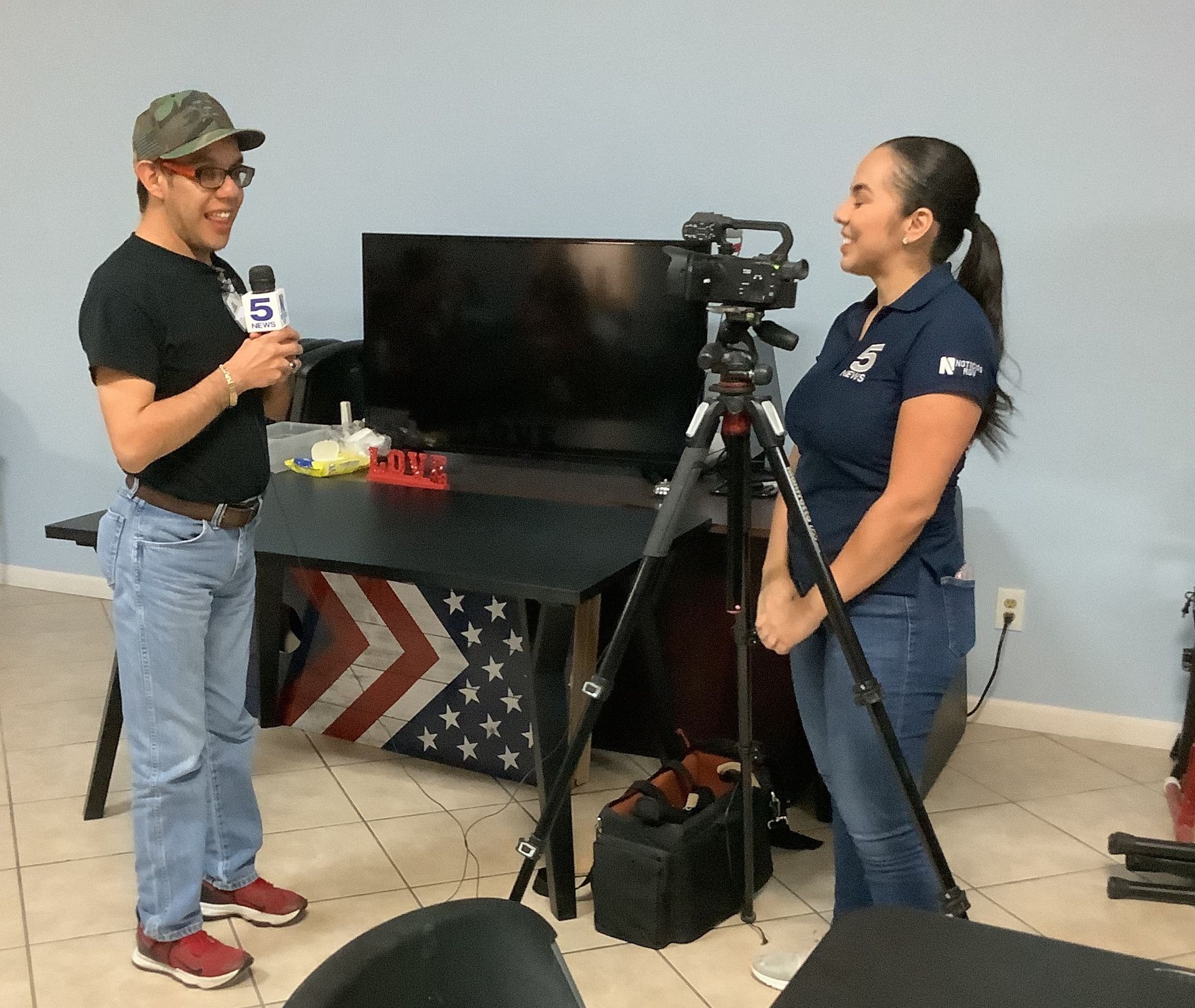 A man is talking to a woman in front of a television