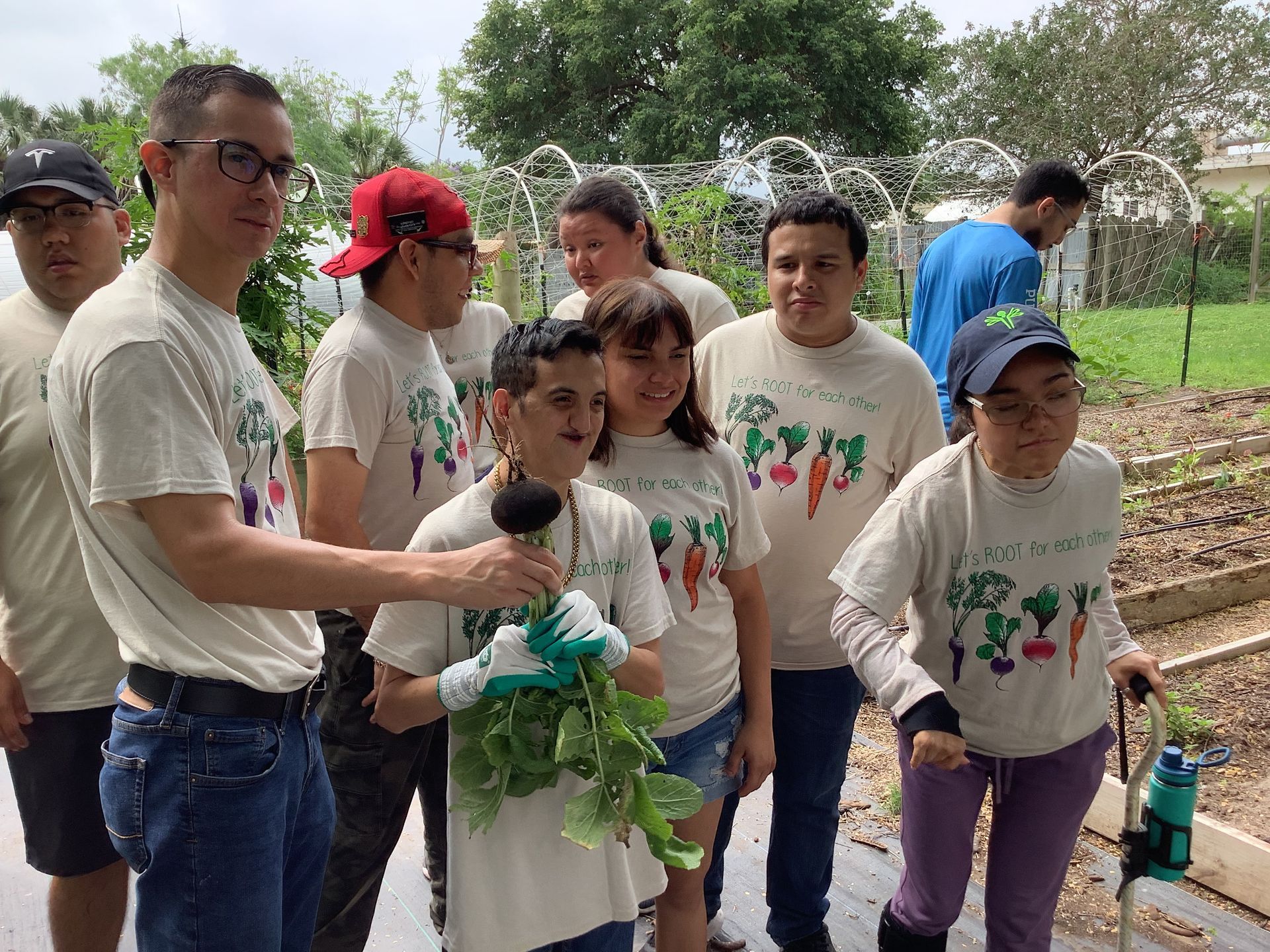 A group of people are standing next to each other in a garden.