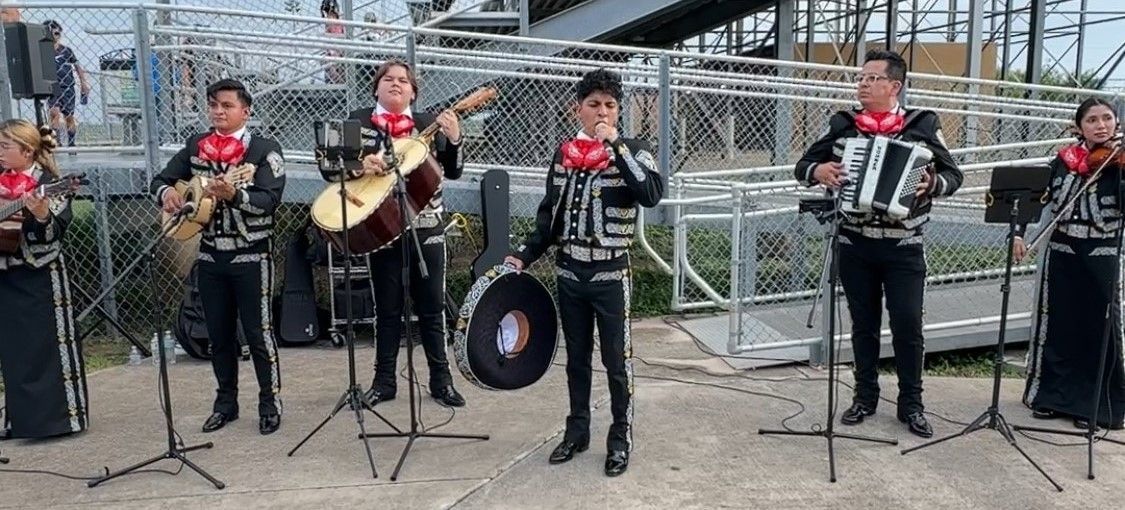 A group of people are standing in front of microphones playing instruments.