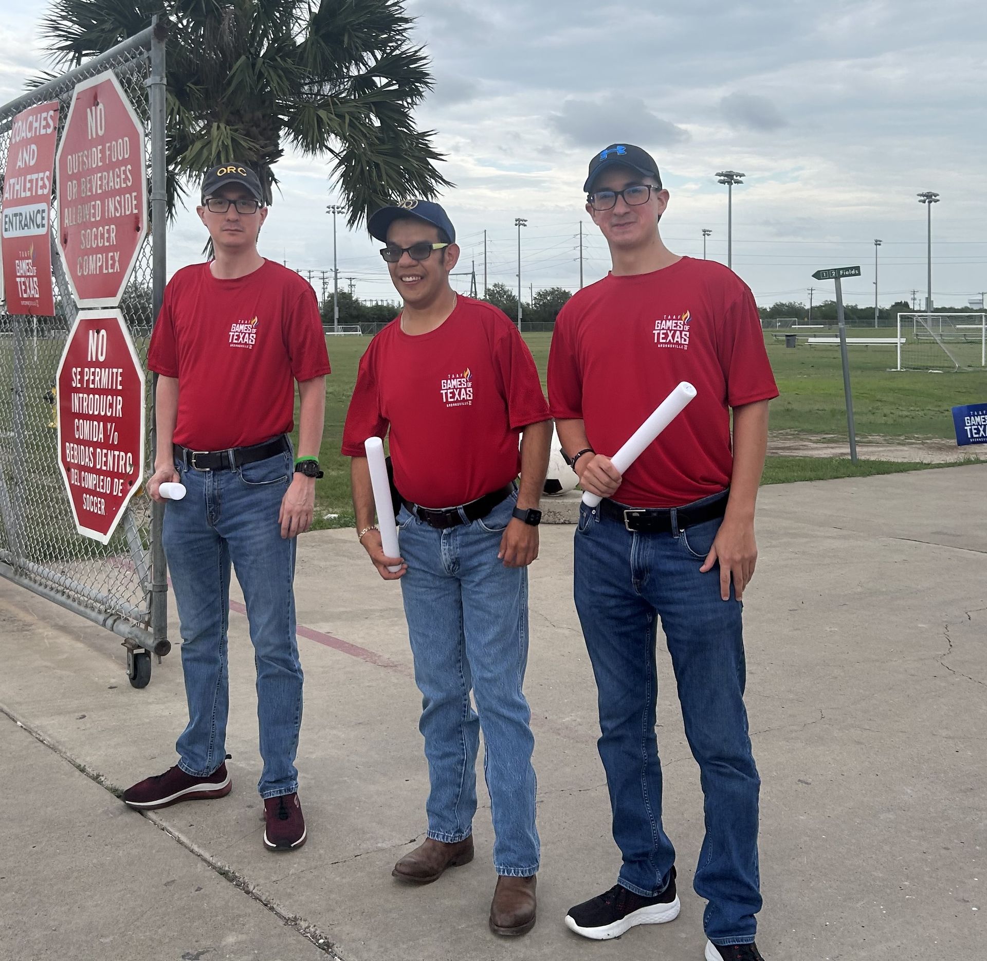 Three men standing in front of a stop sign