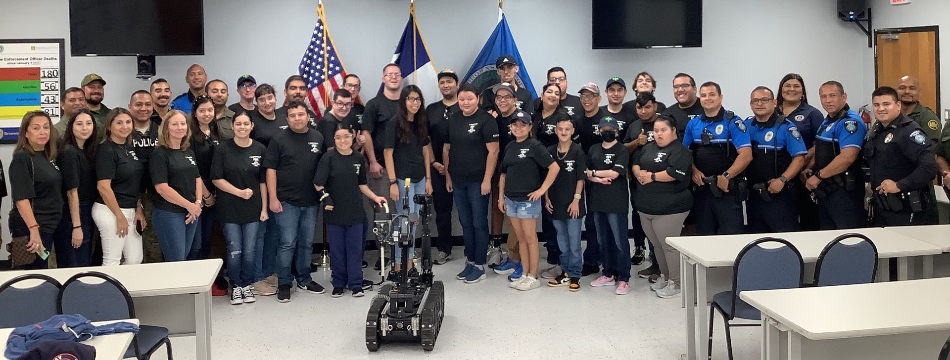 A large group of people are posing for a picture in a room.