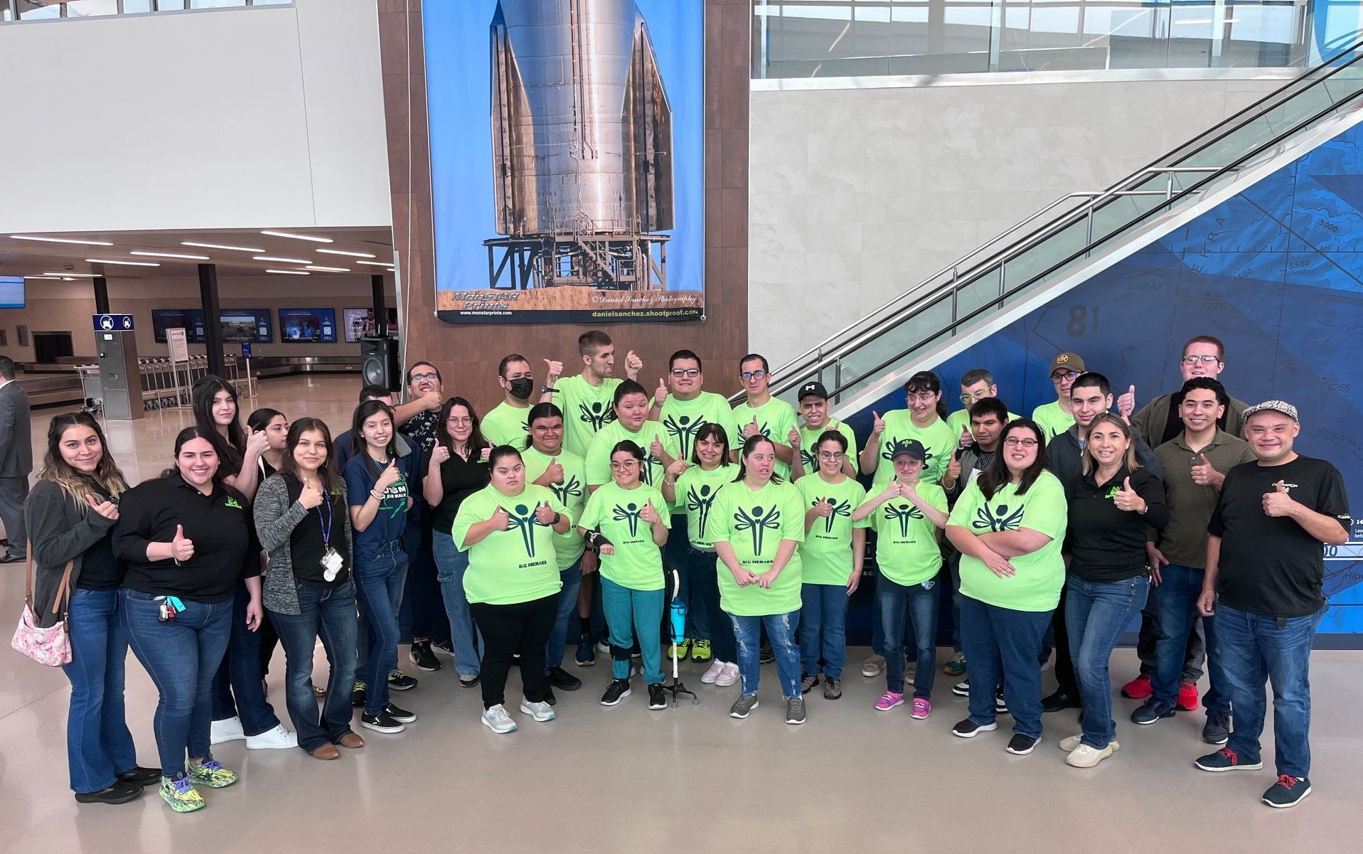A large group of people are posing for a picture in front of a staircase.