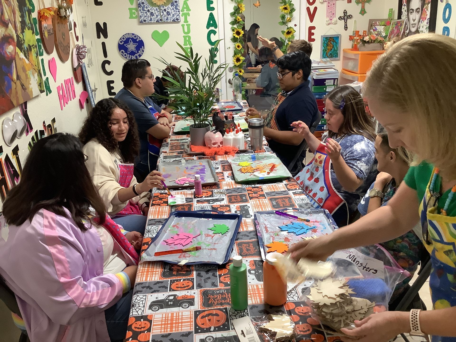 A group of children are sitting at a table making crafts.