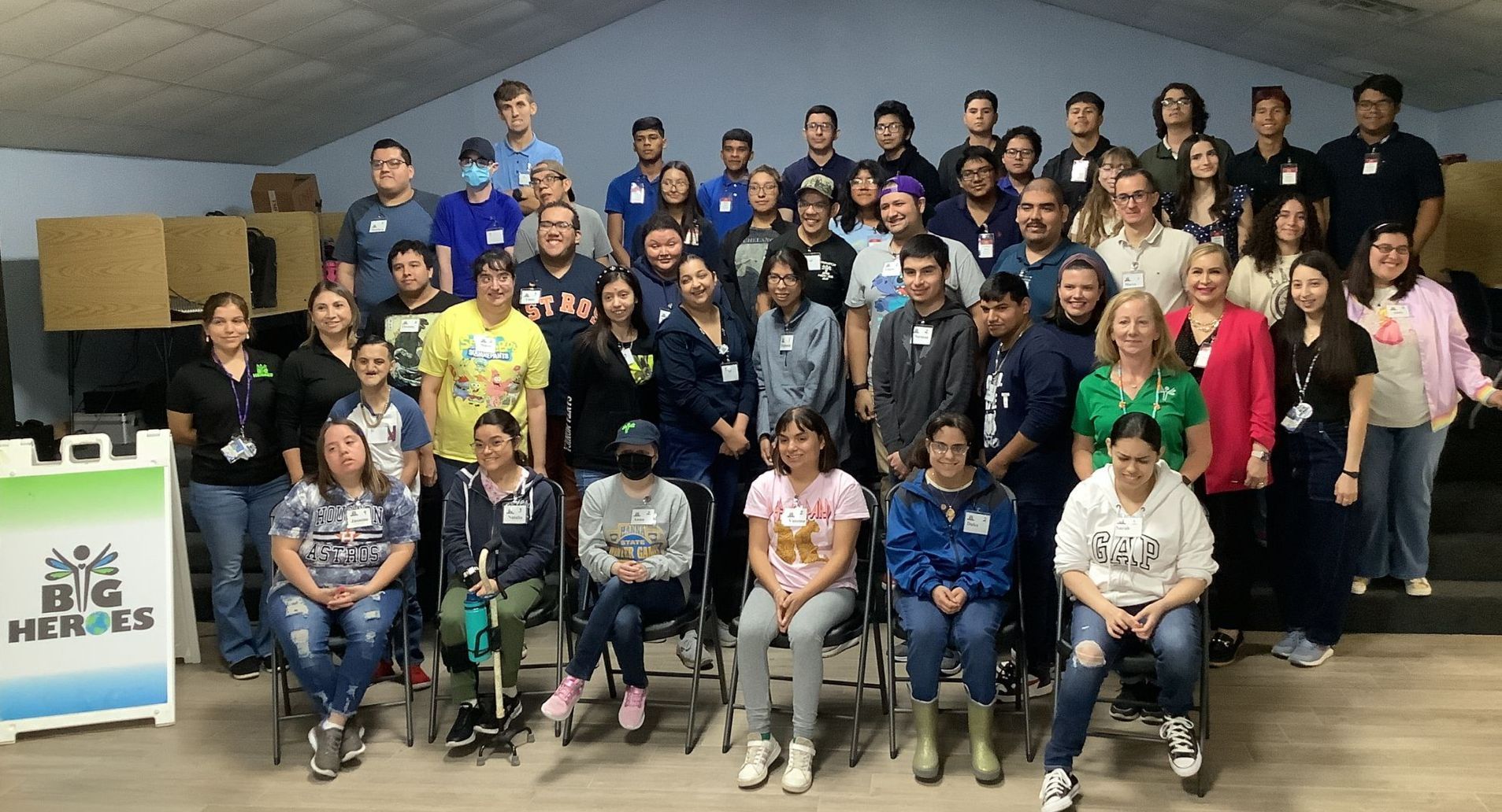 A large group of people are posing for a picture in a room.