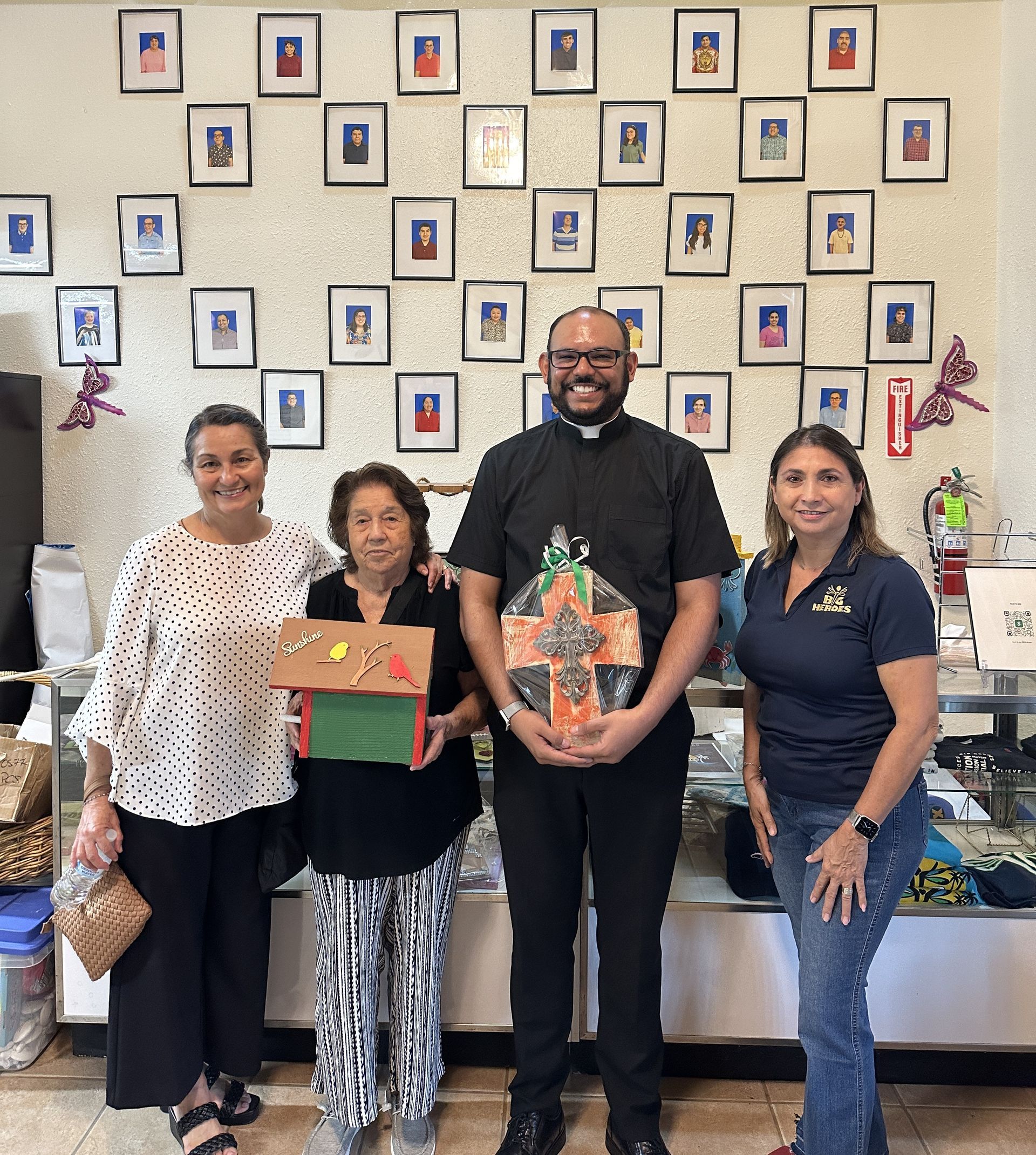 A group of people standing in front of a wall with pictures on it.