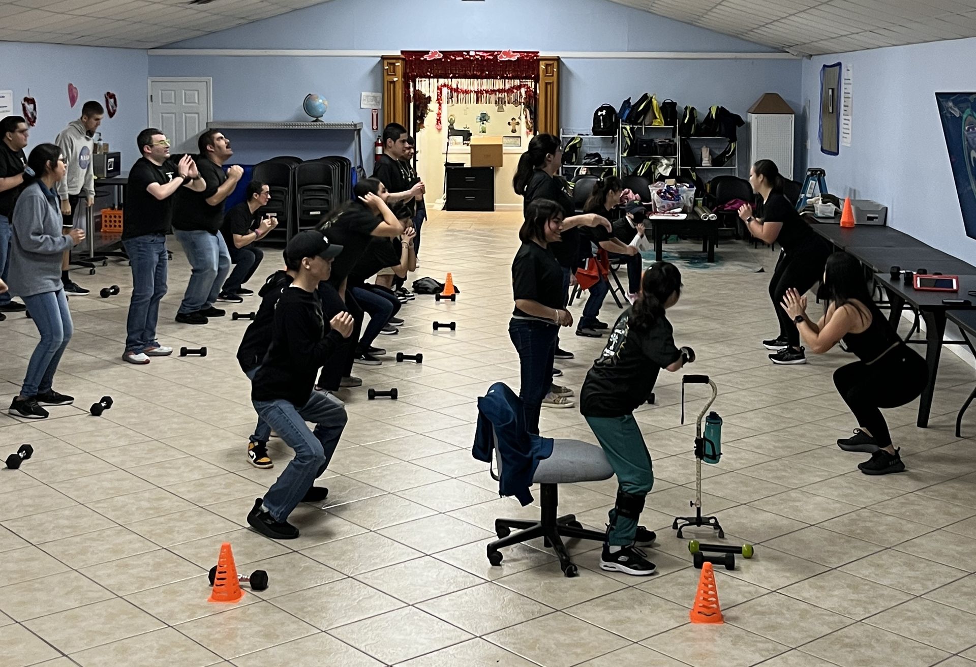 A group of people are doing exercises in a room.