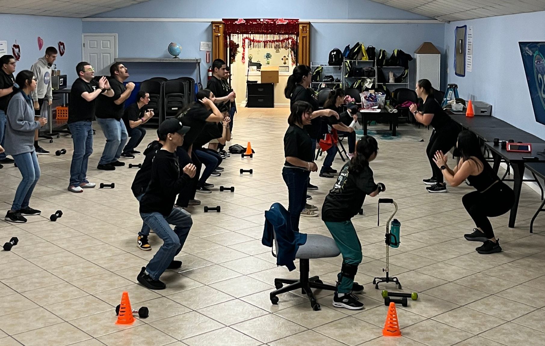A group of people are doing exercises in a room.