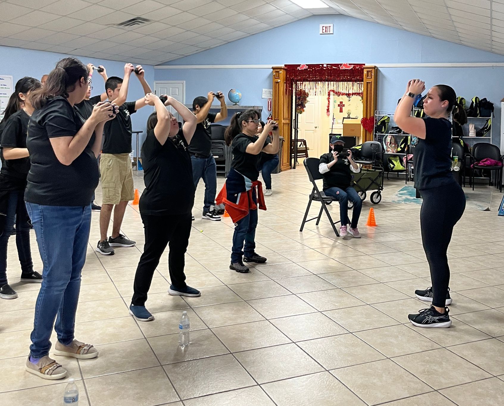 A group of people are standing in a room with their arms in the air.