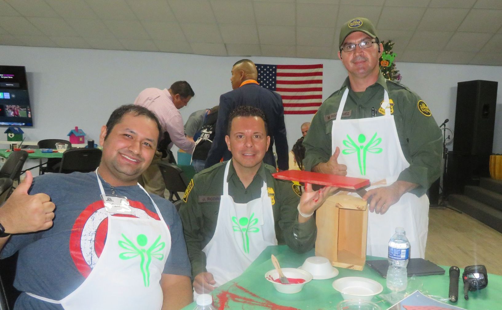 Three men wearing aprons are posing for a picture