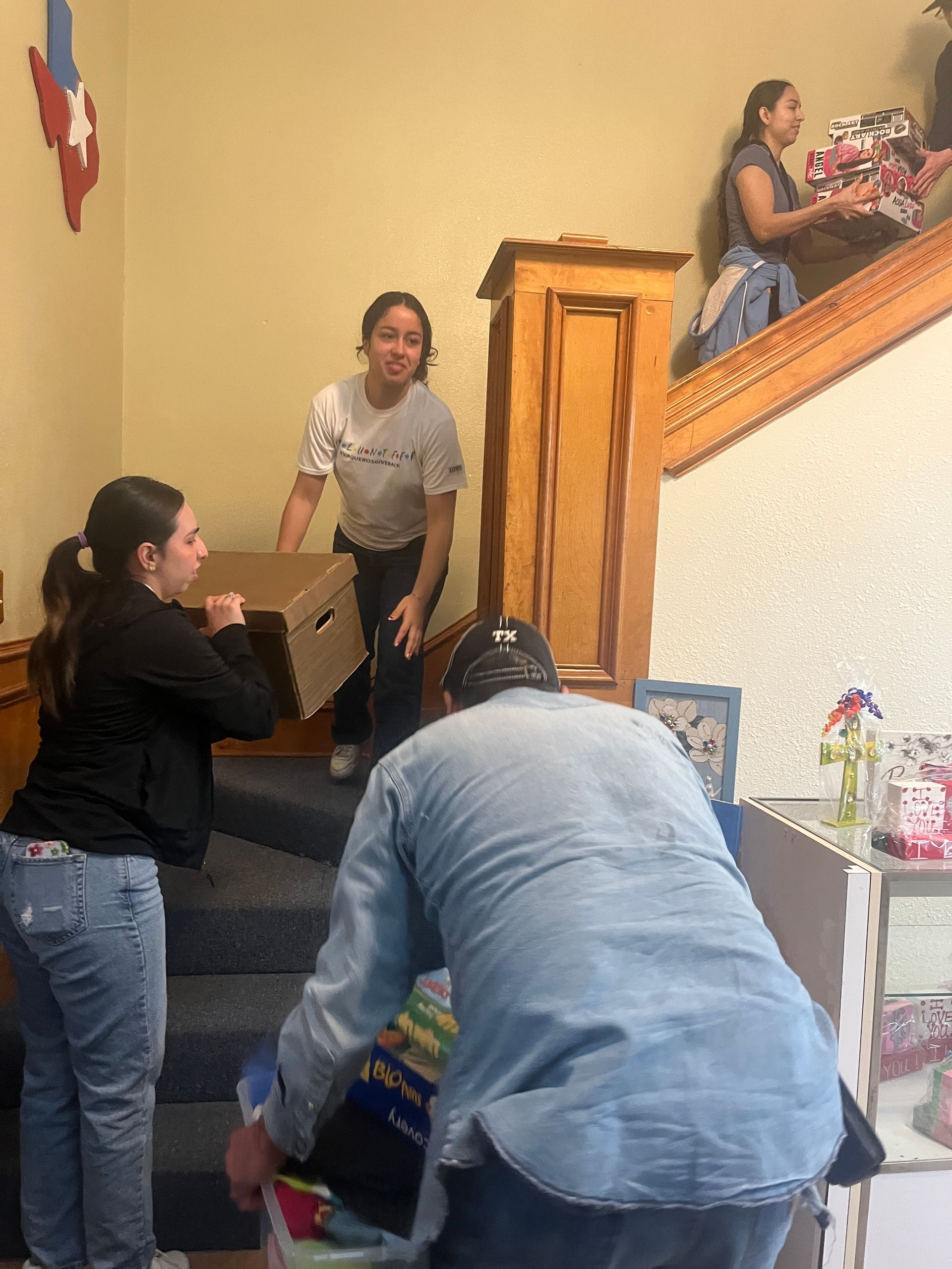 A group of people are moving boxes up a set of stairs.