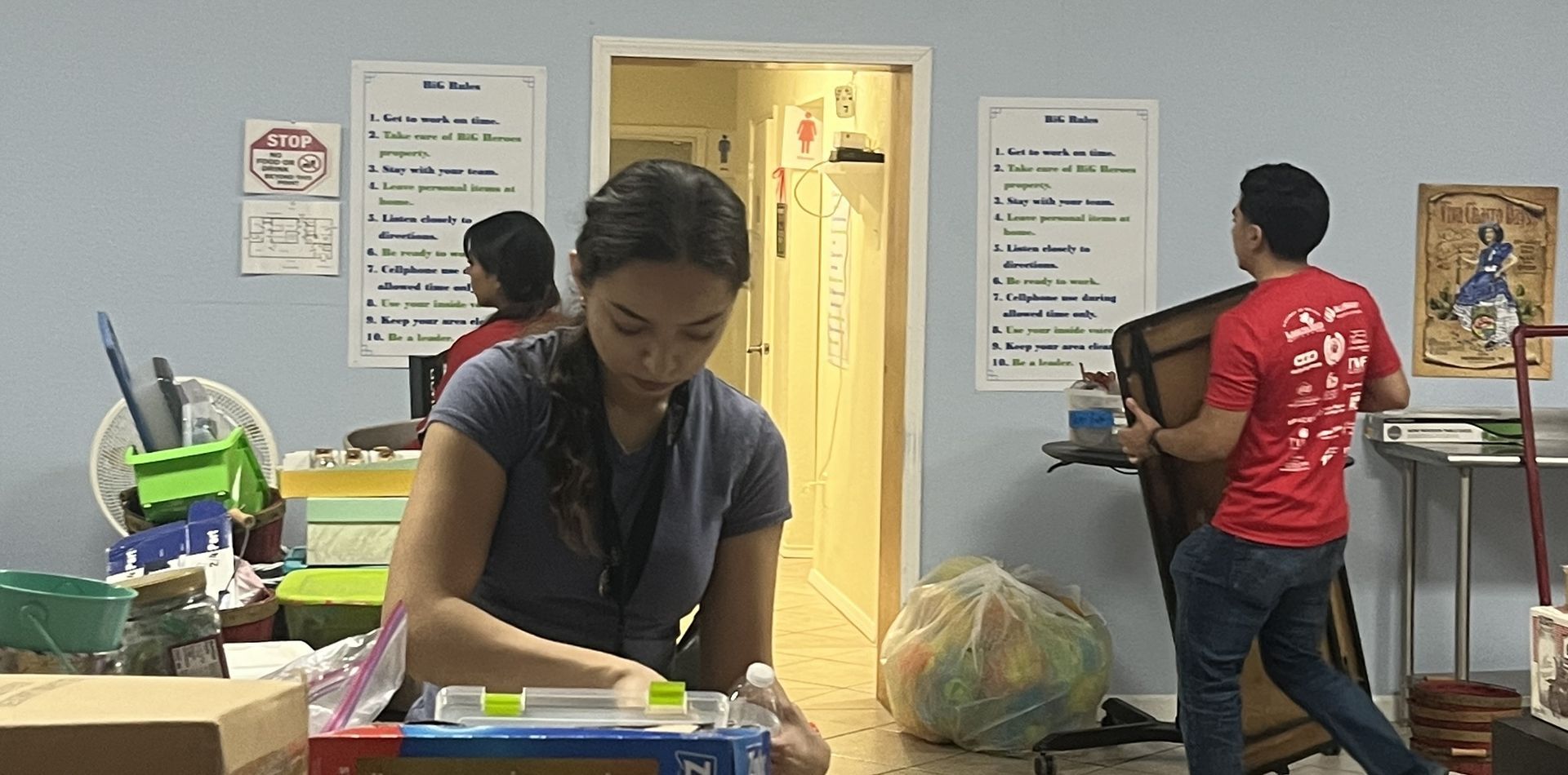 A woman in a gray shirt is standing next to a man in a red shirt.