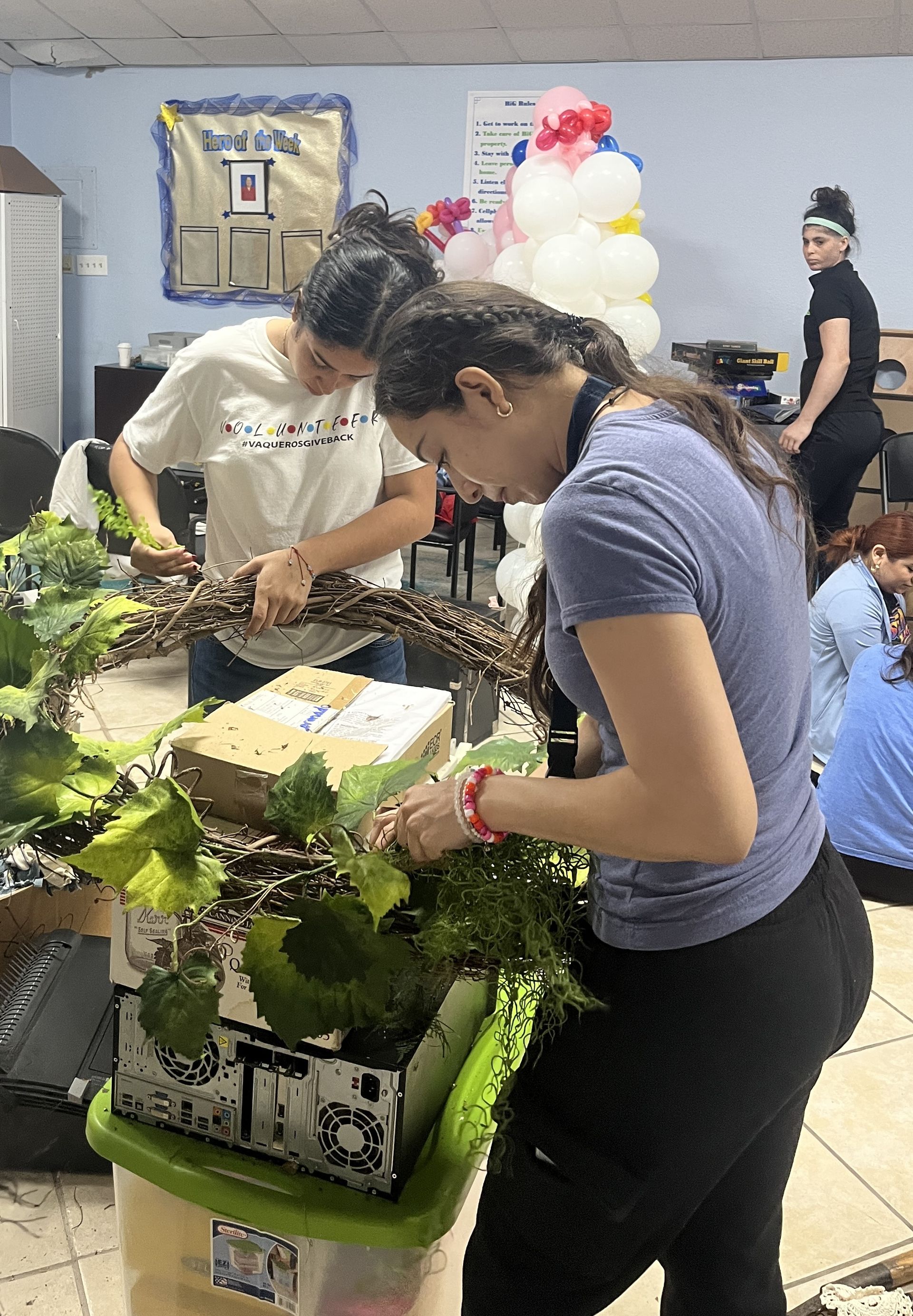 A group of women are working on a wreath in a room.