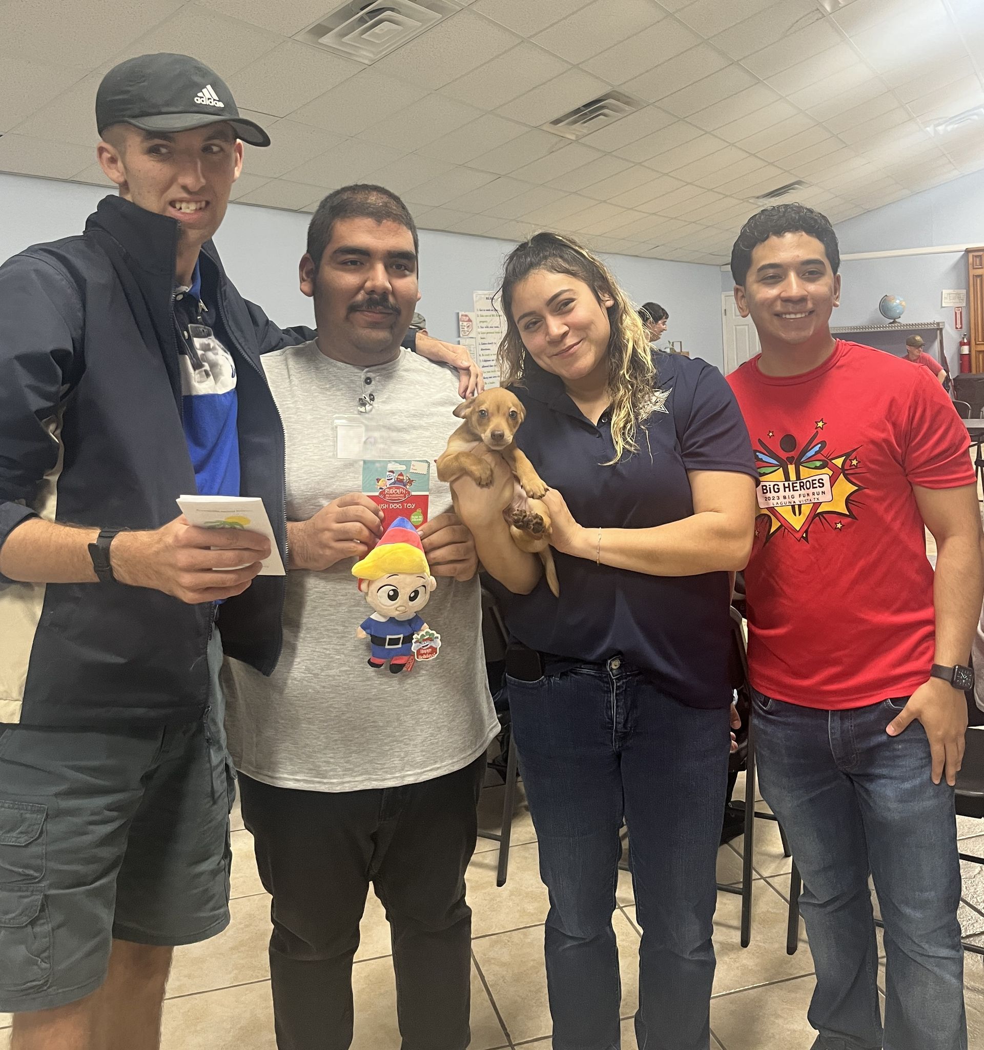 A group of people posing for a picture with a puppy