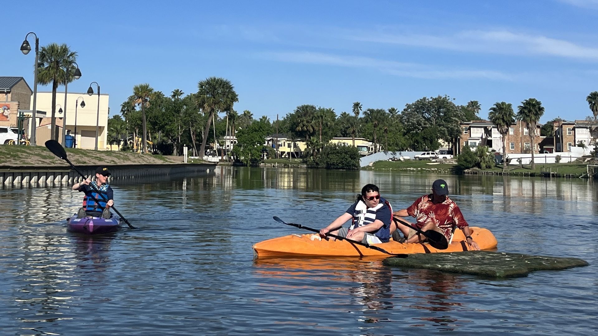 A group of people are riding kayaks on a lake.