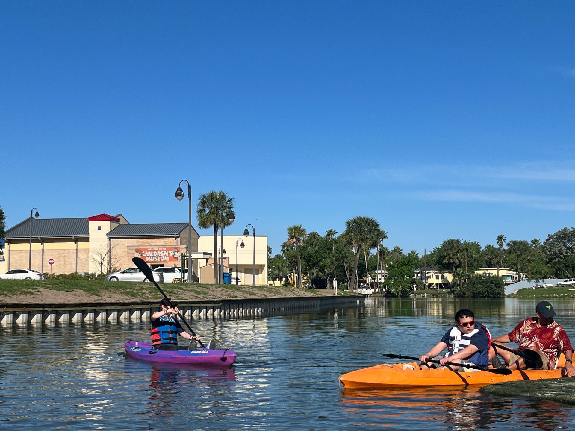 A group of people are paddling kayaks on a lake