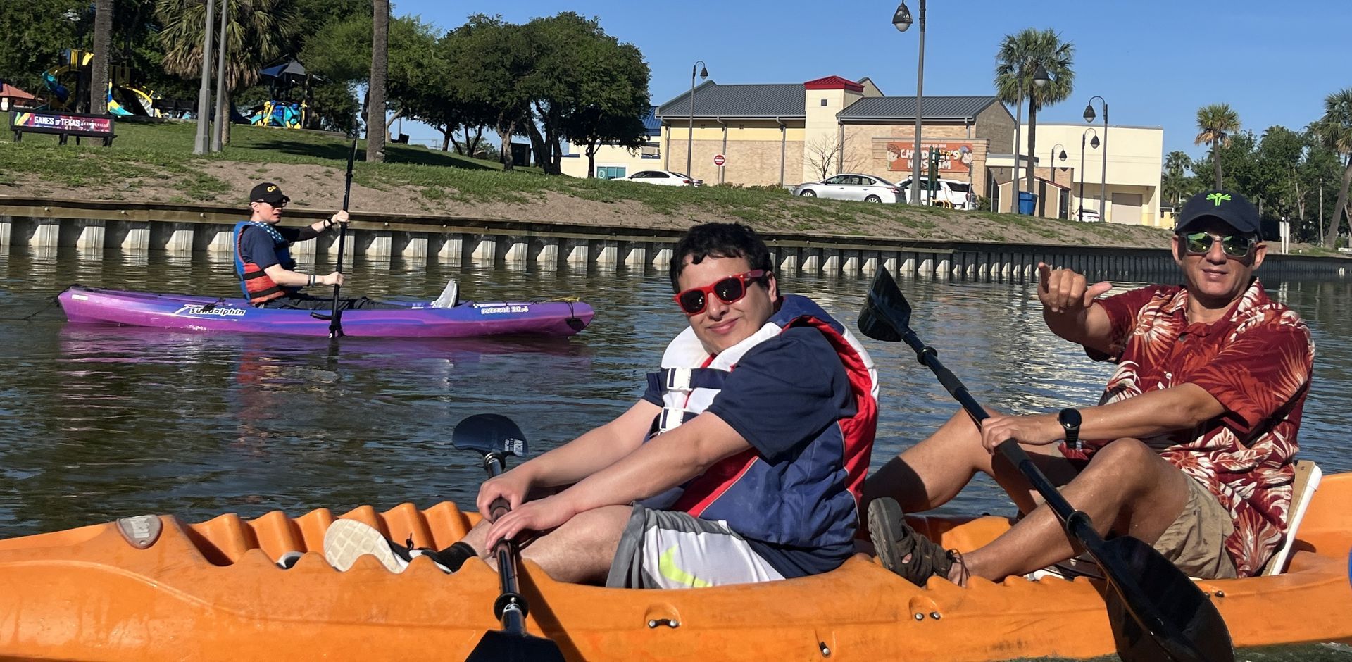 A group of people are rowing kayaks on a river.