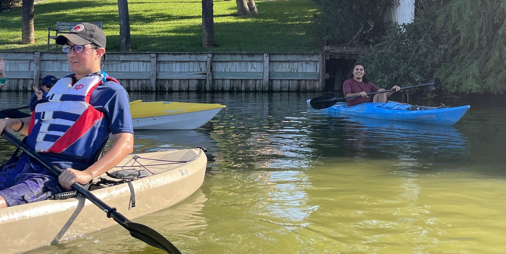A man is sitting in a kayak with a paddle in the water.