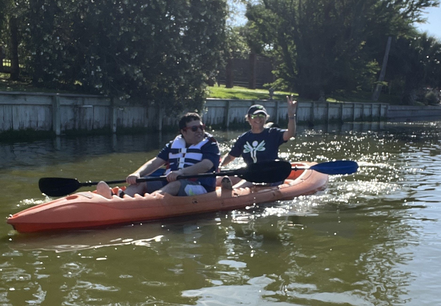 A man and a woman are in a kayak on a lake.