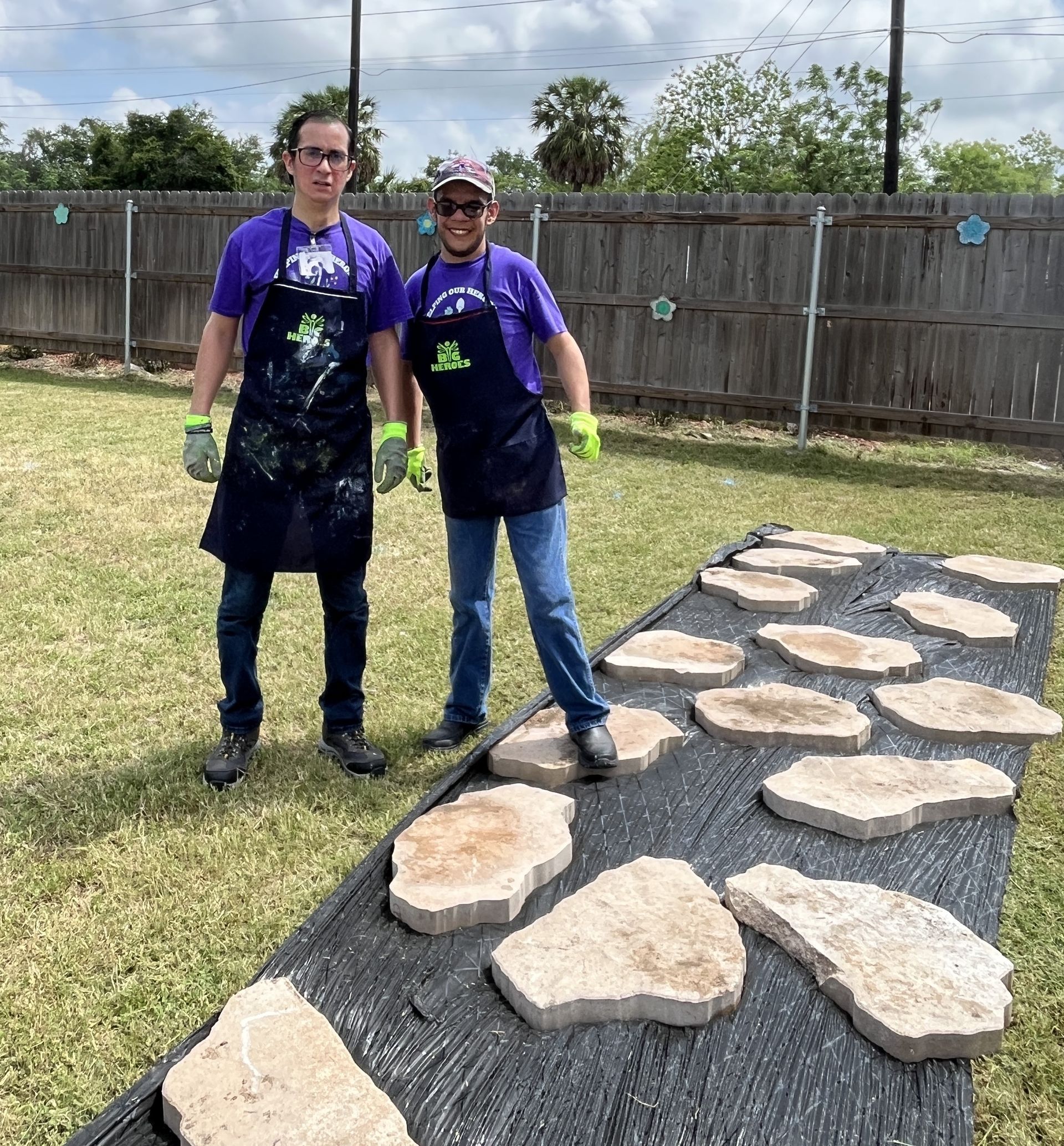 A man and a woman are standing next to each other on a path made of rocks.