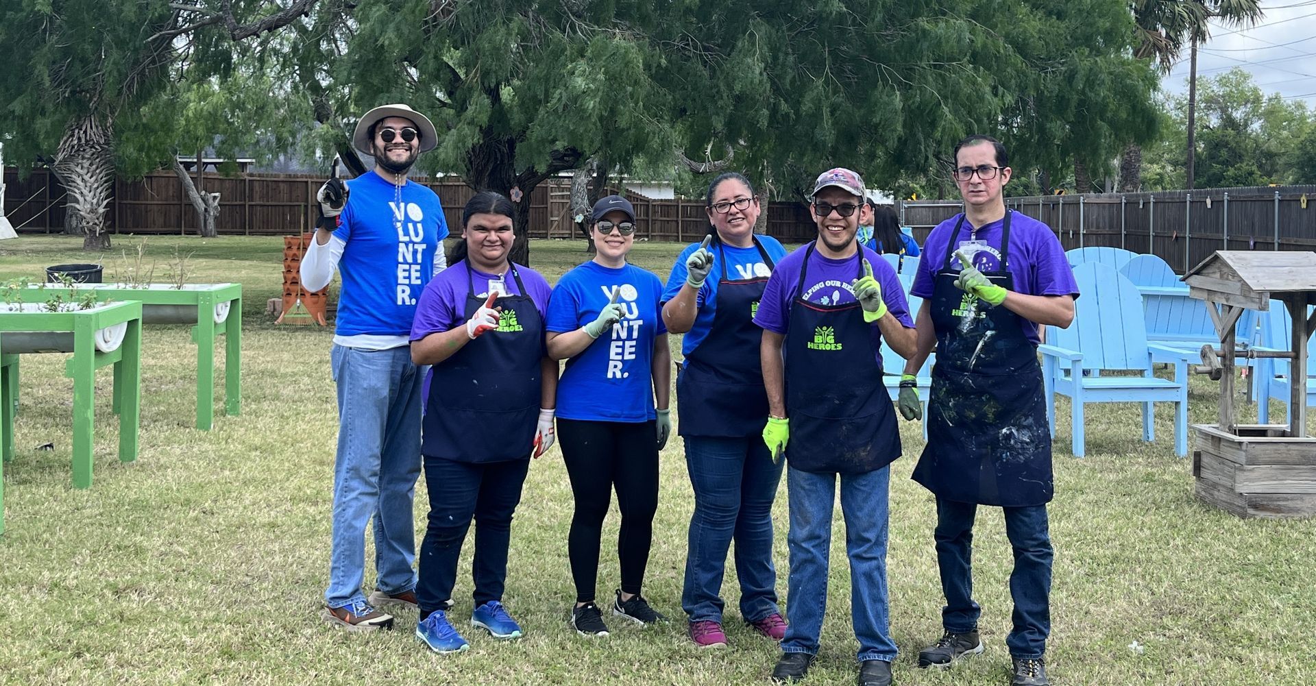 A group of people are posing for a picture in a park.