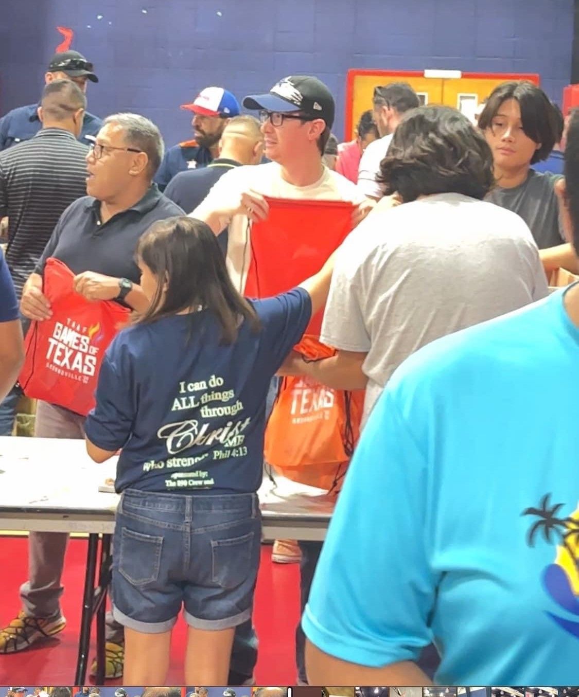 A group of people are standing around a table holding bags that say texas