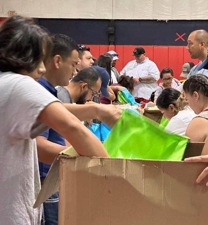 A group of people are standing around a cardboard box.