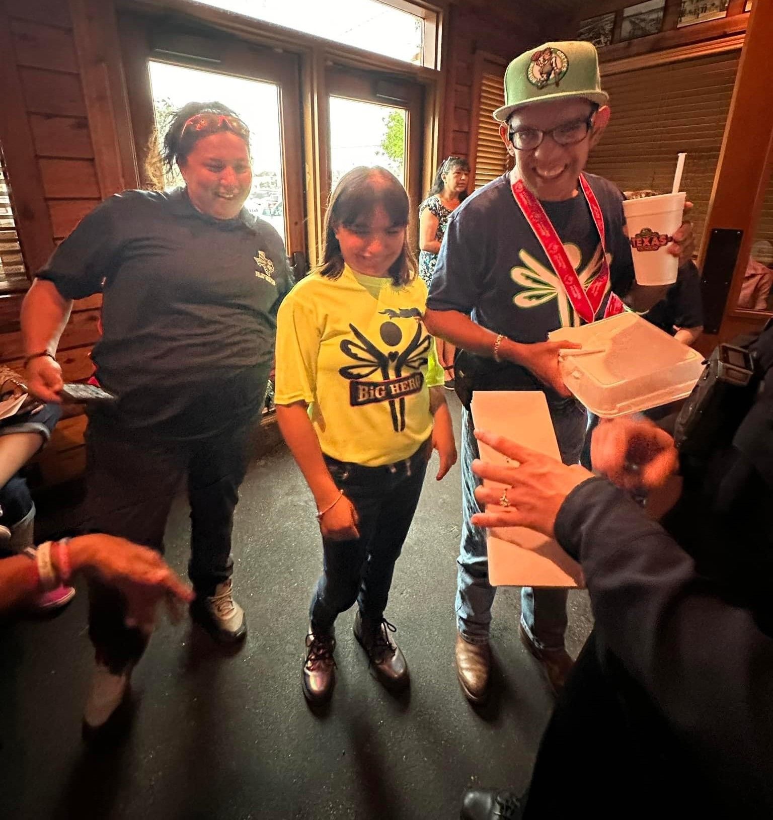 A group of people are standing in a room and one of them is wearing a shirt that says do n't worry