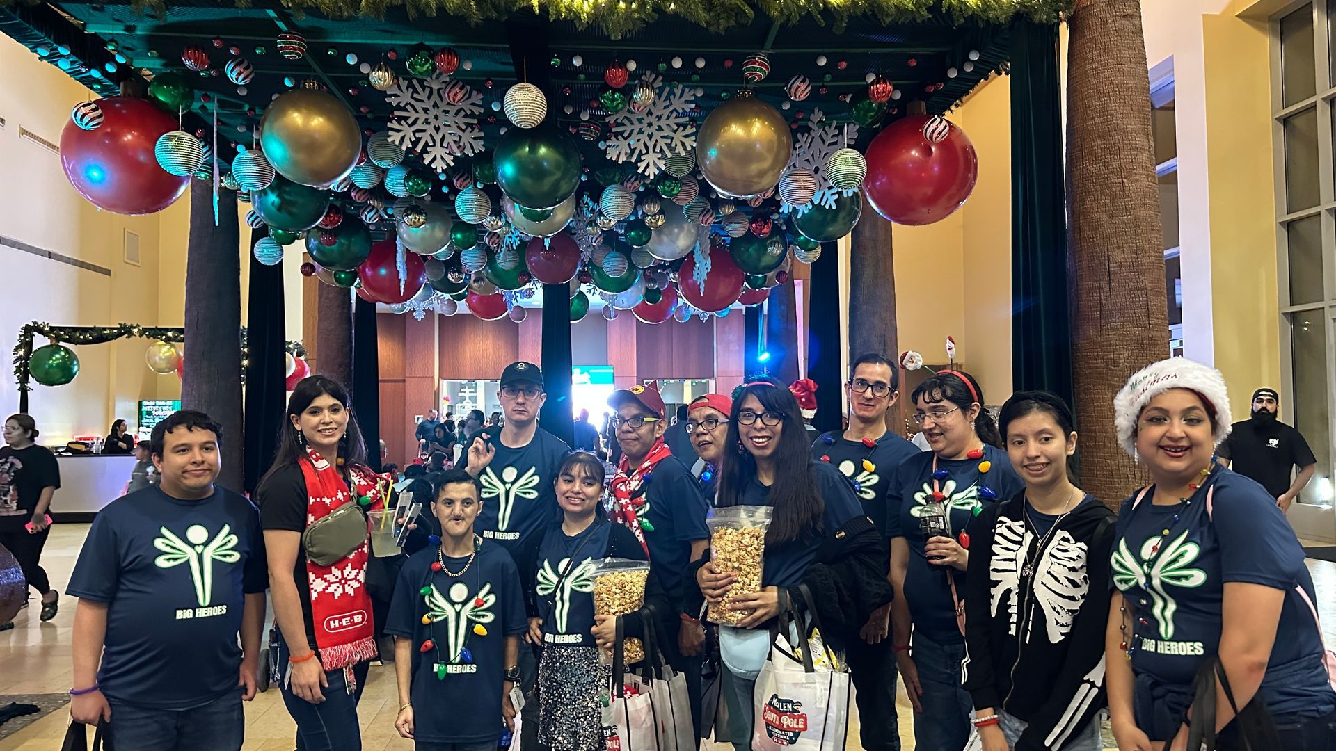 A group of people are posing for a picture in front of a christmas tree.