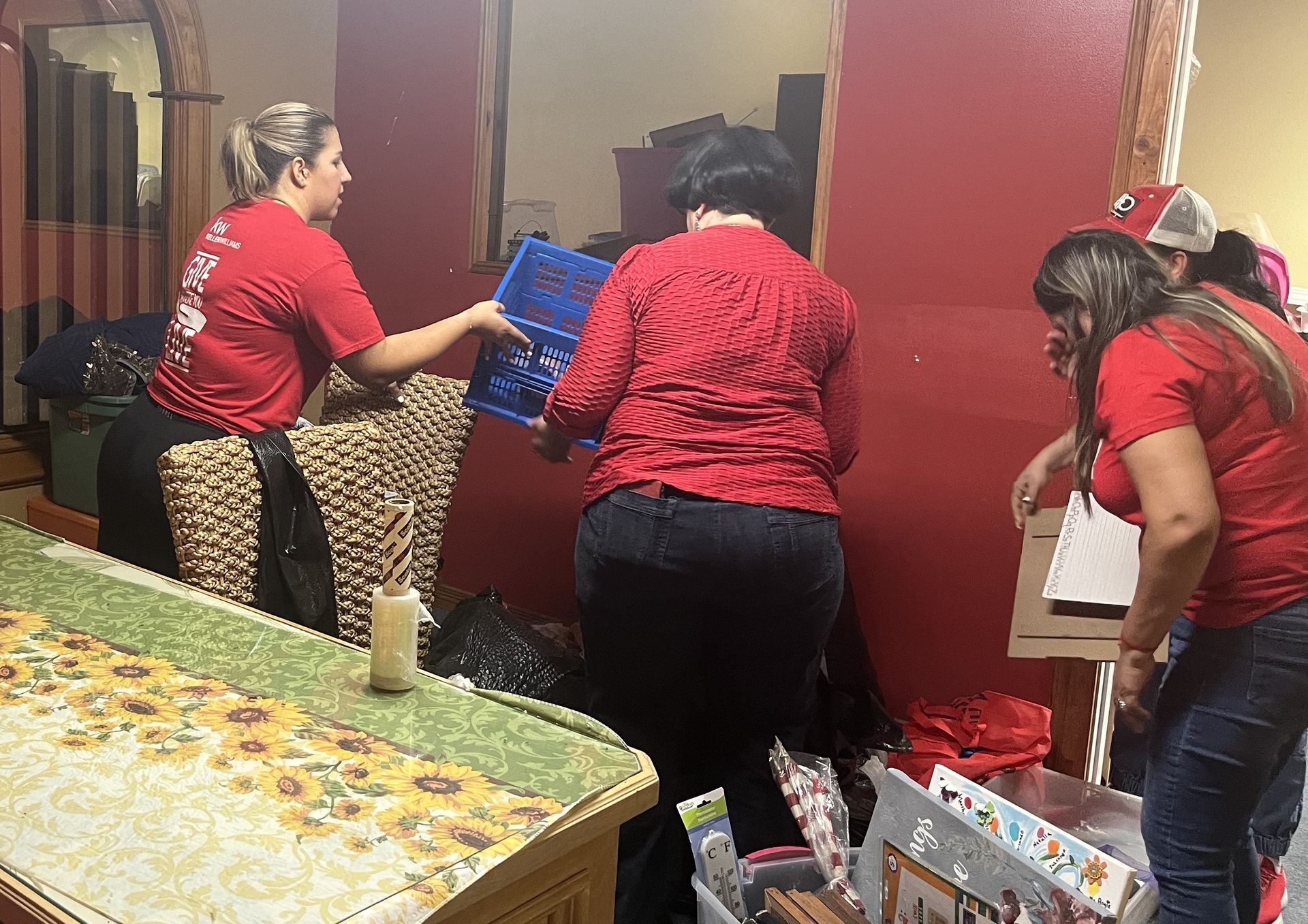 A group of women in red shirts are standing in a room.