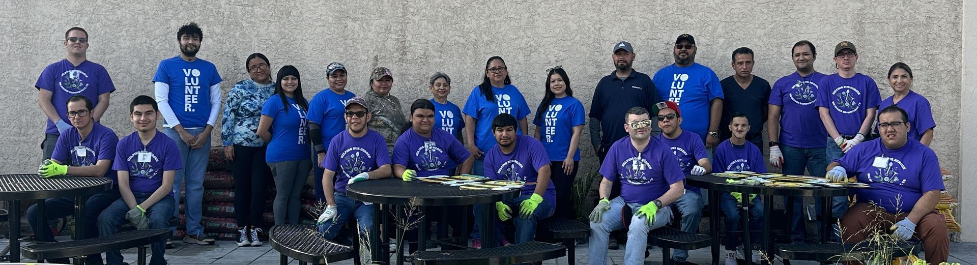 A large group of people in purple shirts are posing for a picture.