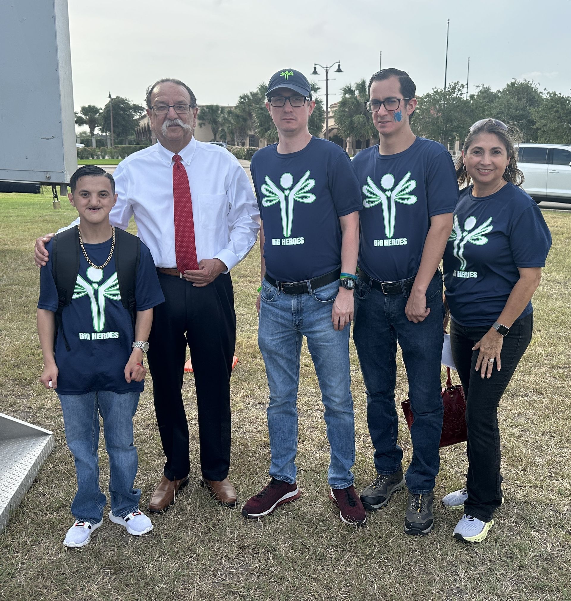 A group of people are posing for a picture and one of them is wearing a shirt with a butterfly on it
