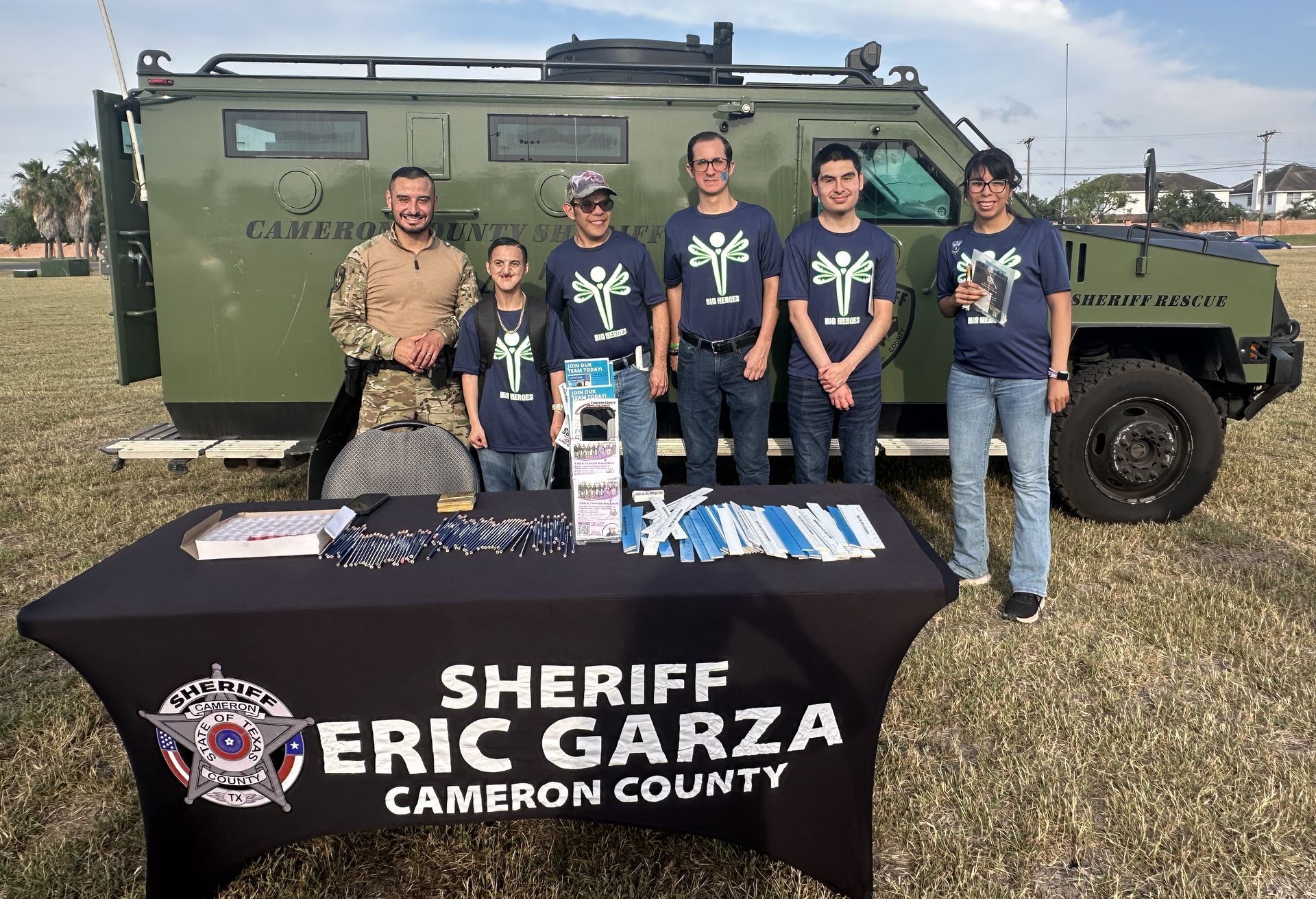 A group of people standing in front of a table that says sheriff eric garza cameron county