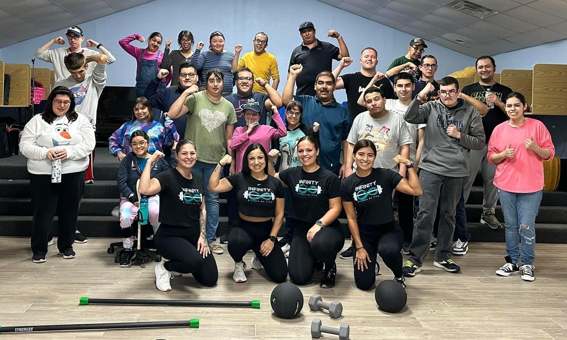 A group of people are posing for a picture in a gym.