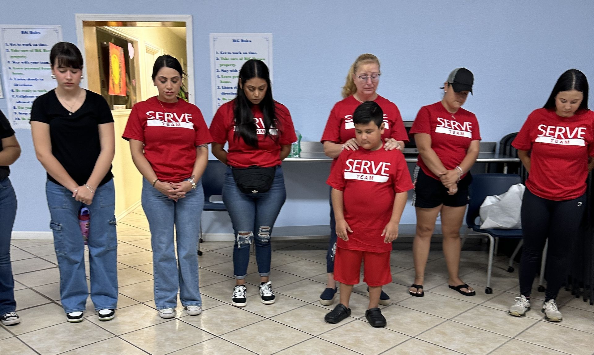 A group of people wearing red shirts that say serve