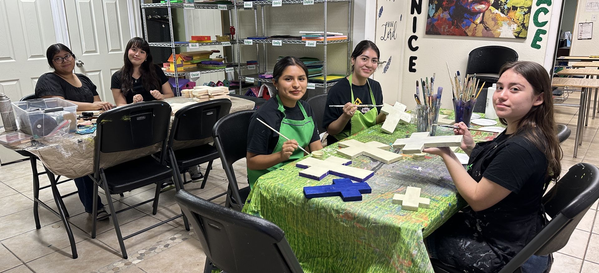 A group of women are sitting around a table in a room.