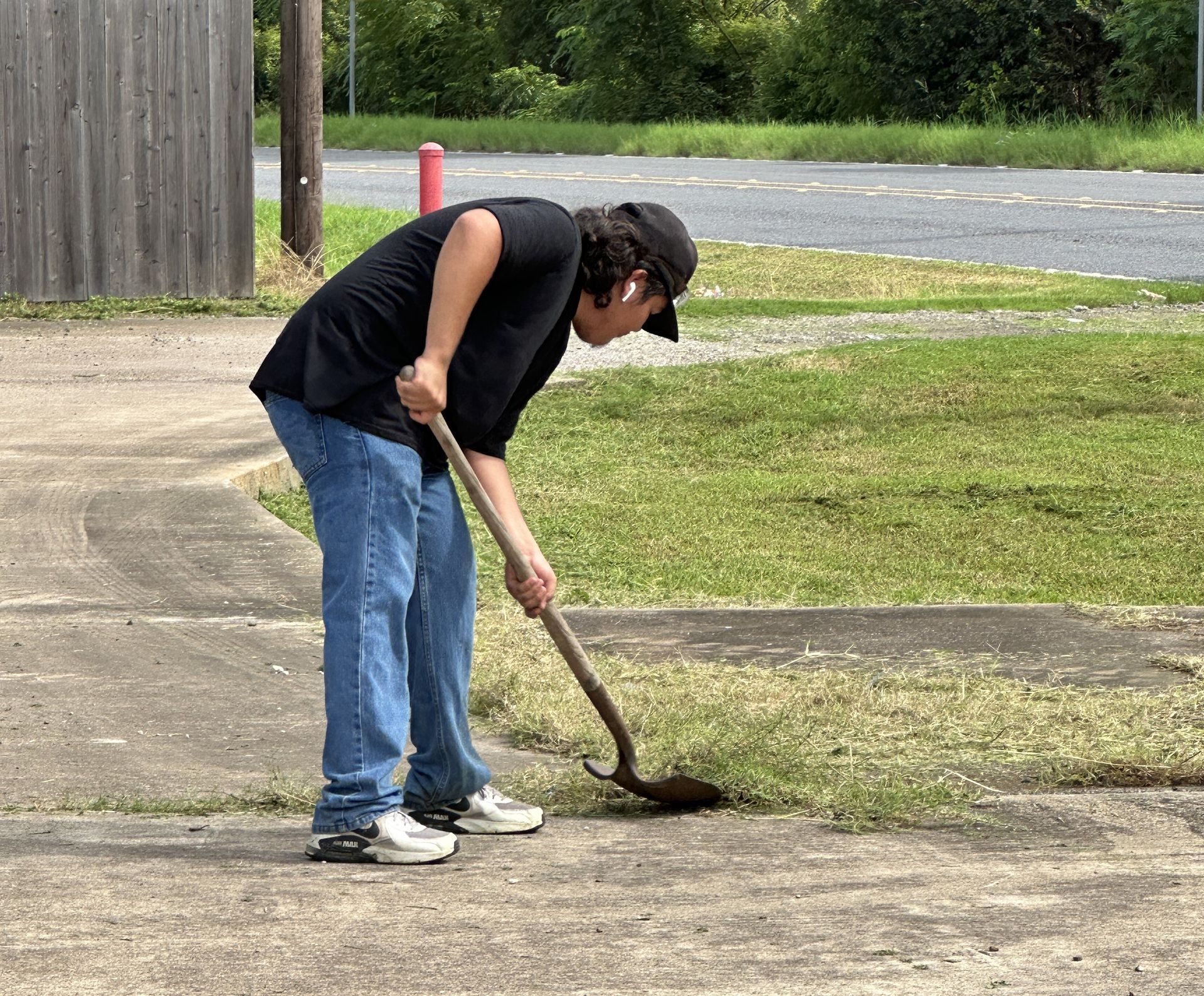 A man is digging a hole in the ground with a shovel.