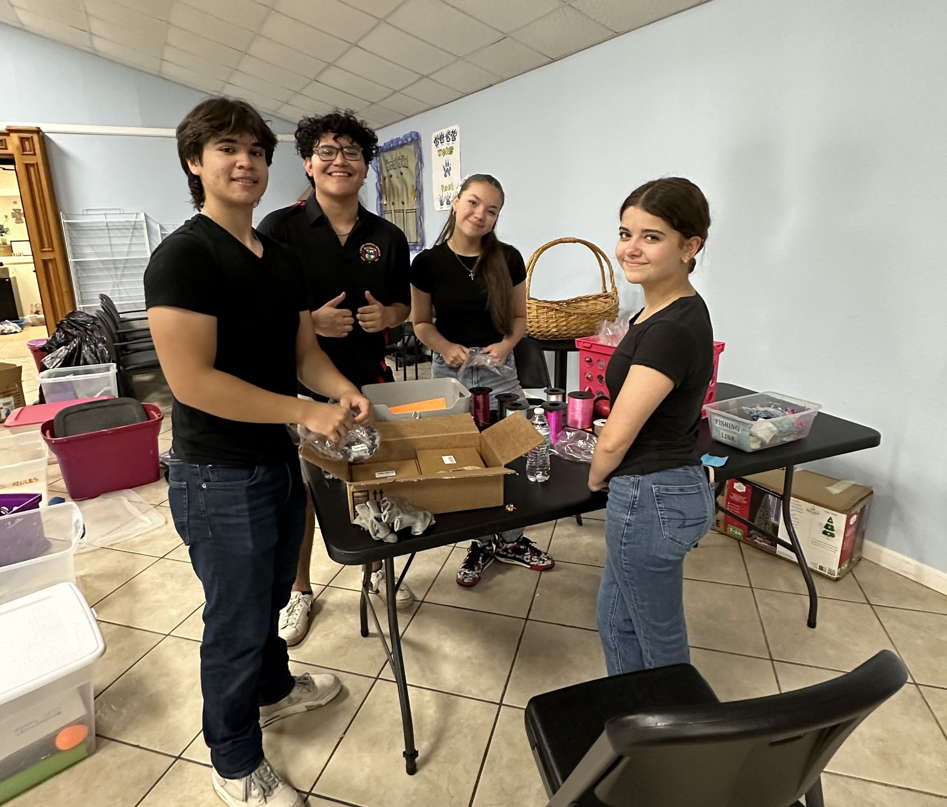 A group of people are standing around a table in a room.