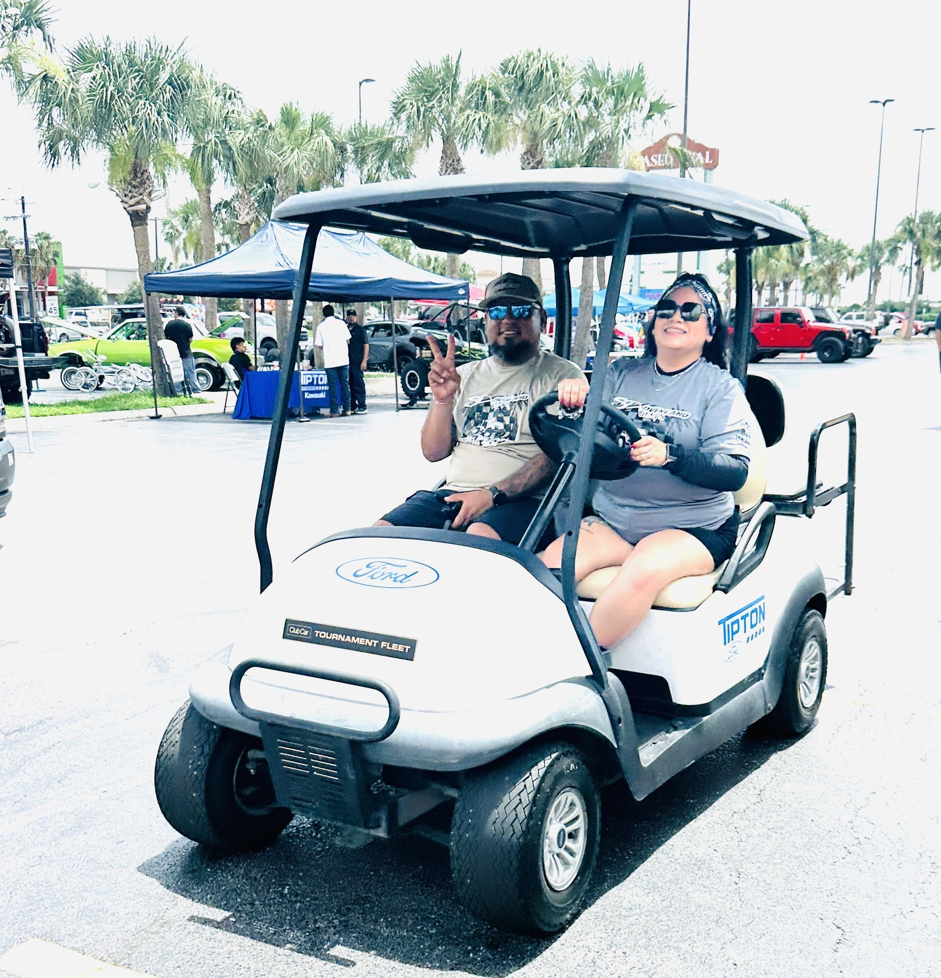 A man and a woman are riding a golf cart