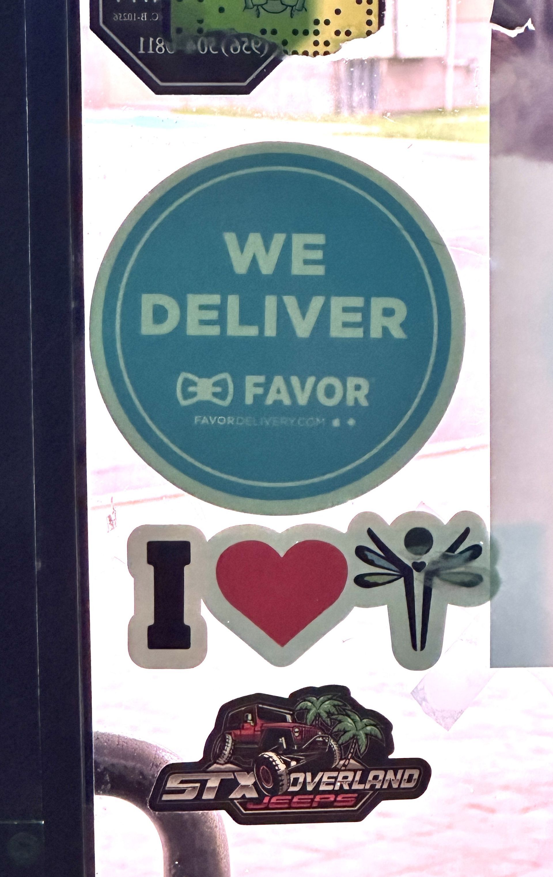 A sticker on a door that says we deliver favor
