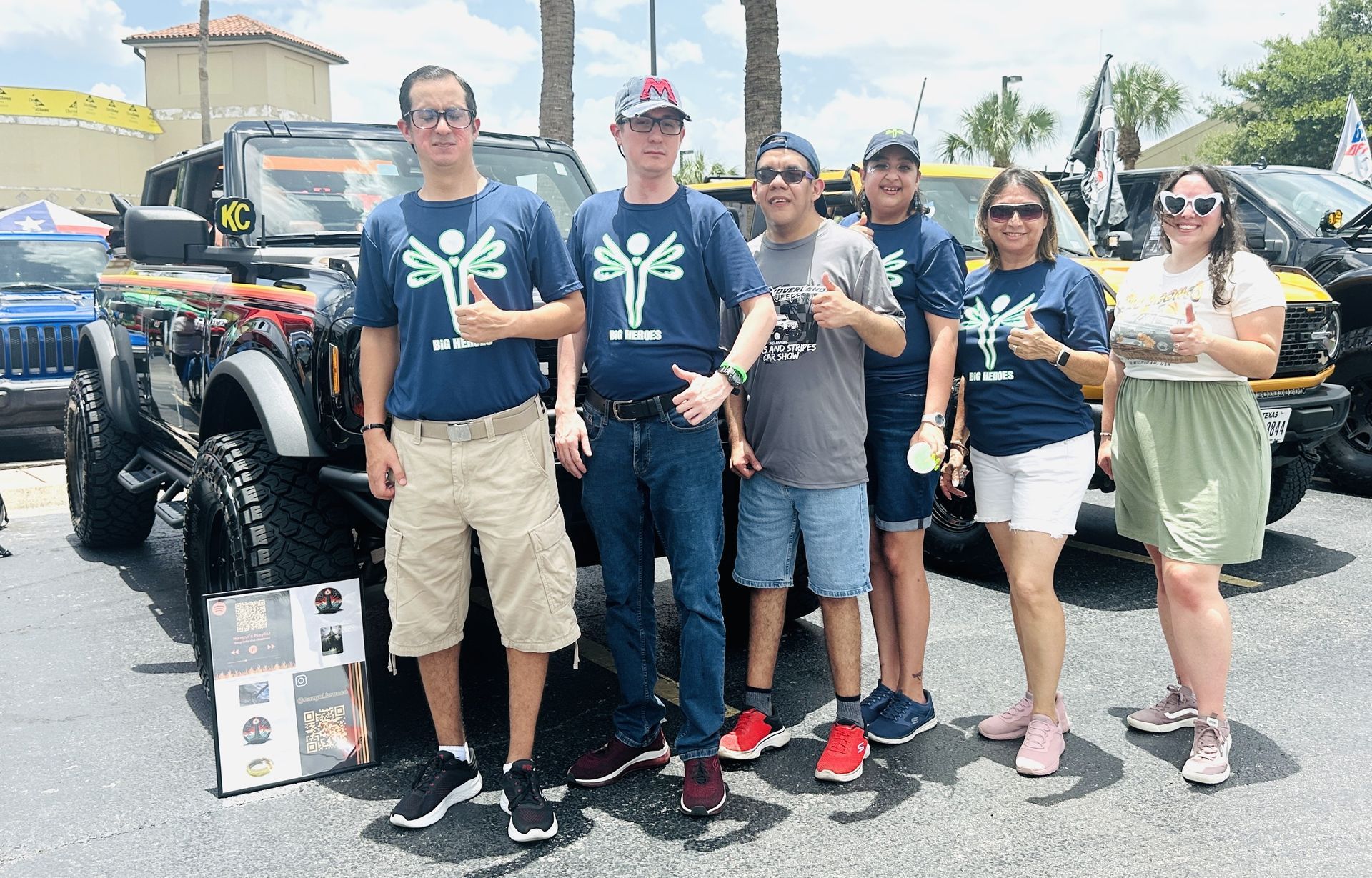 A group of people are posing for a picture in front of a jeep.