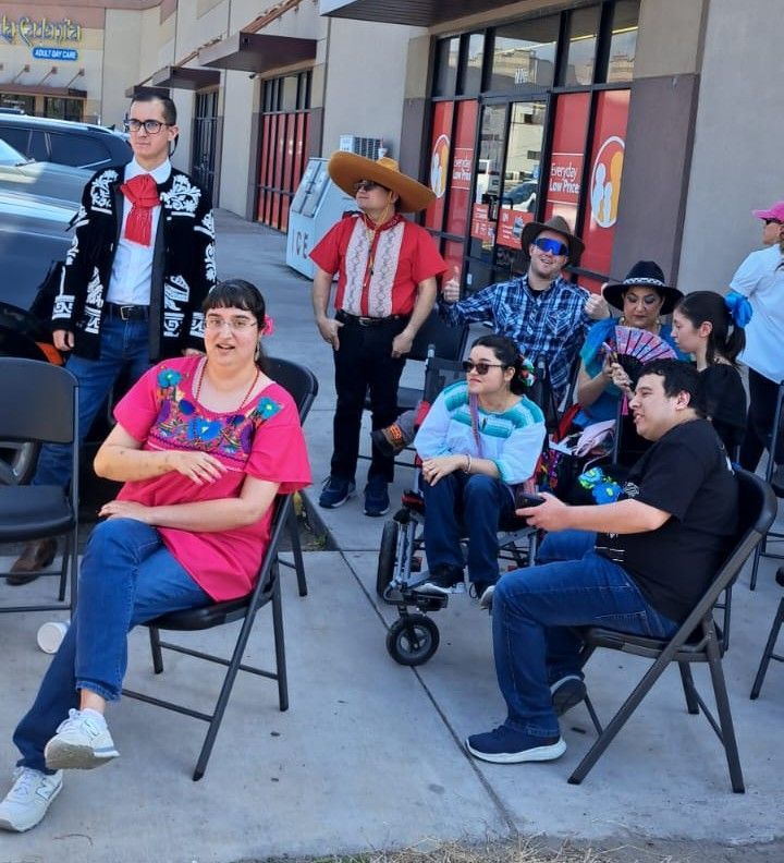A group of people are sitting in chairs outside of a store