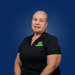 A woman in a black shirt is sitting in front of a blue background.
