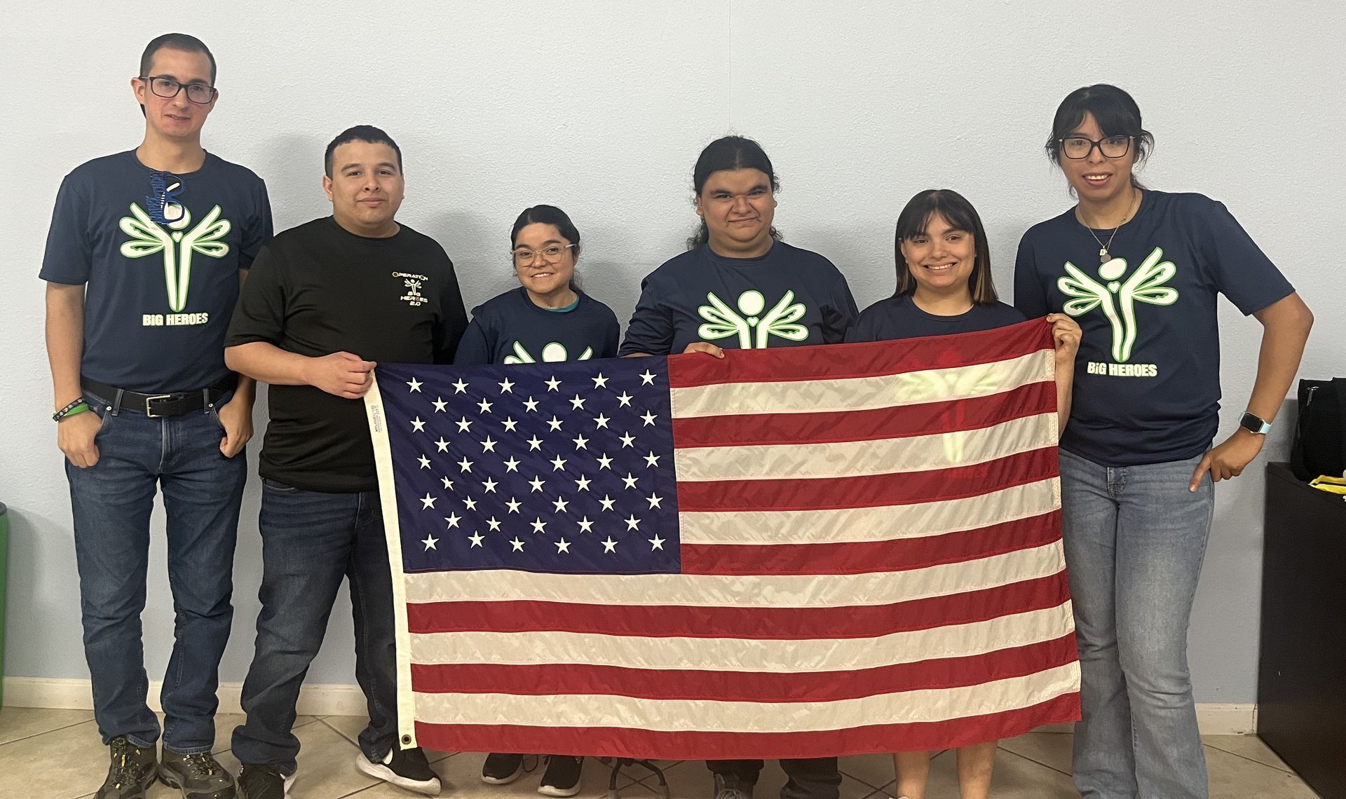 A group of people are standing next to each other holding an american flag.