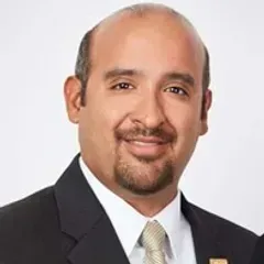 A man in a suit and tie is smiling for the camera.