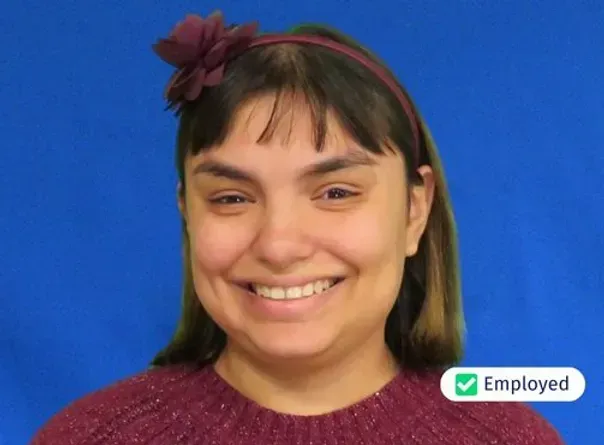 A woman wearing a headband and a red sweater is smiling and has the word employed next to her