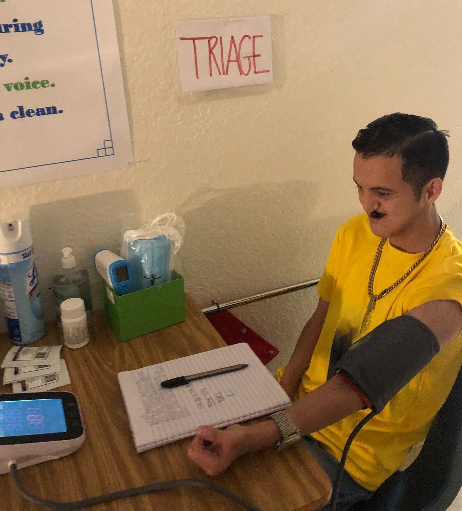 A man sitting at a desk with a sign that says triage