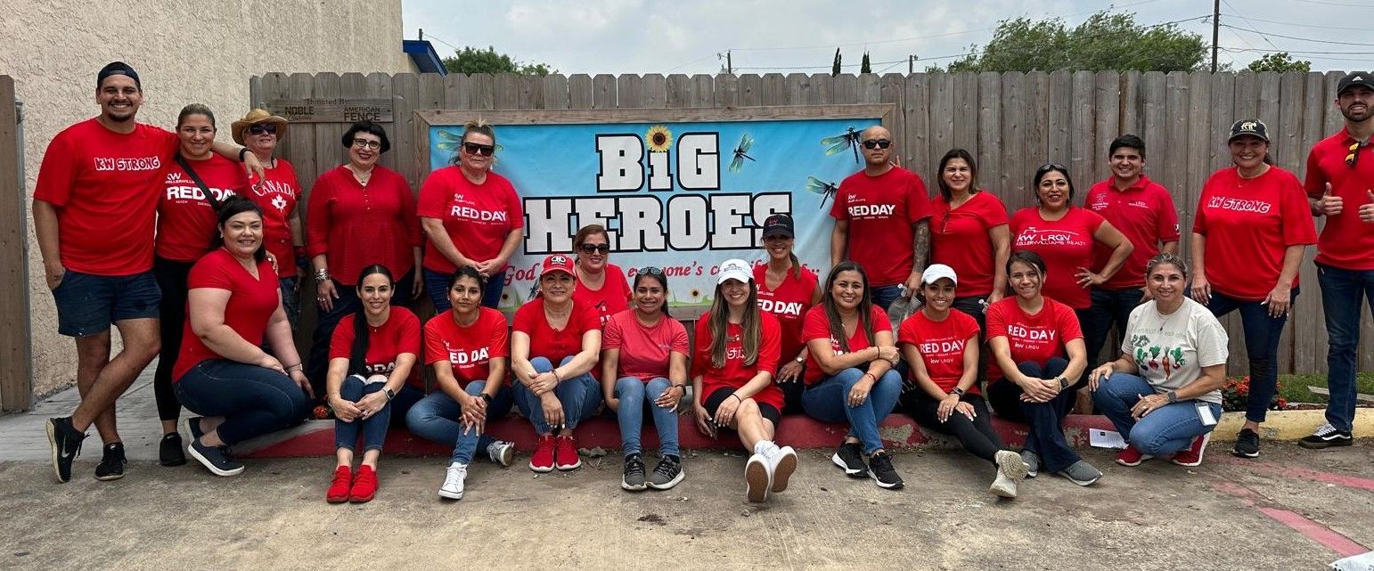A group of people wearing red shirts are posing for a picture.